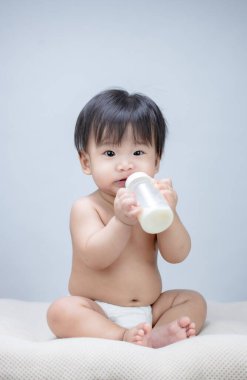 Şişe tutan tatlı bir bebek. 
