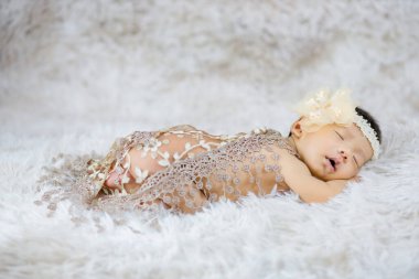Beyaz yün halılarda çiçek bandı takan şirin Newborn 'u kapat, moda konsepti.