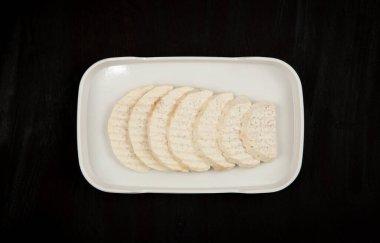 Beyaz arkaplanda izole edilmiş bir tabak üzerinde Taro dilimi.