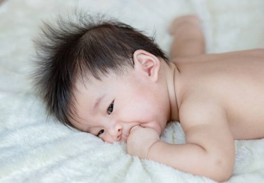 Küçük şirin bebeğin portresi yatağa uzanıyor.