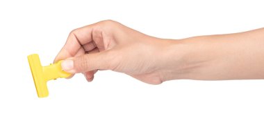 El ele tutuşan sarı paslanmaz çelik ataç beyaz arka planda izole edilmiş. 