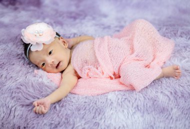 Mor yün halılarda çiçek bandı takan şirin Yenidoğan 'ı kapat, moda kavramı.