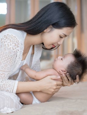 Güzel, genç bir anne tatlı küçük bebeğine bakıyor..