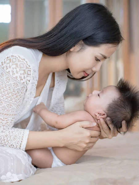 Güzel, genç bir anne tatlı küçük bebeğine bakıyor..