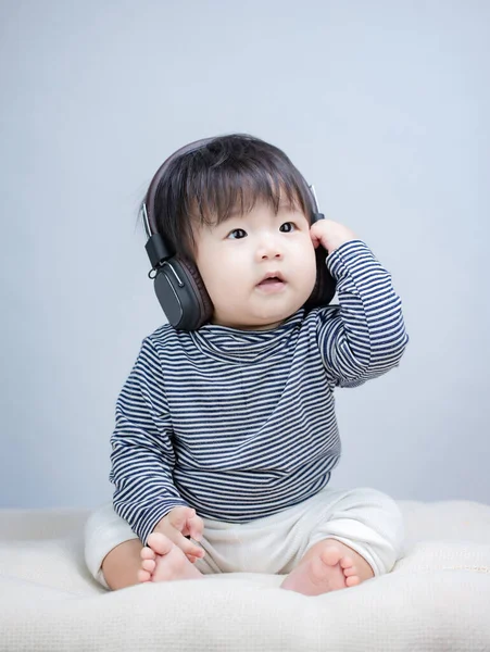 Roztomilý Chlapeček Sedí Poslouchá Hudbu Sluchátku — Stock fotografie