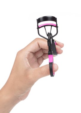 El ele tutuşan kirpik kıvırıcı pembe beyaz arka planda izole edilmiş..