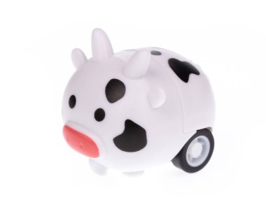 Oyuncak inek kendini beyaz bir arka planda yalnız bulur..