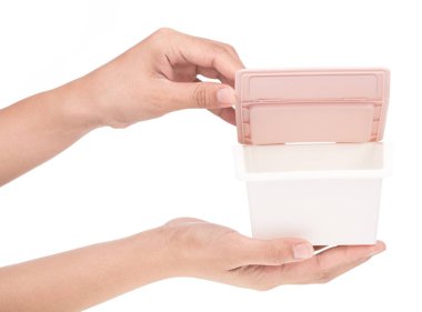 El ele tutuşan küçük plastik kutu beyaz arka planda izole edildi.