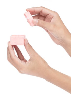 El ele tutuşan pembe hediye paketi beyaz arka planda izole edilmiş kurdele ve yay