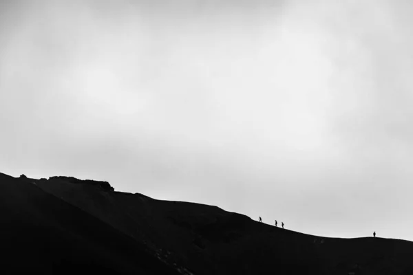 Minimalistyczny Obraz Małej Sylwetki Mężczyzn Wspinających Się Krawędź Krateru Wulkanu — Zdjęcie stockowe