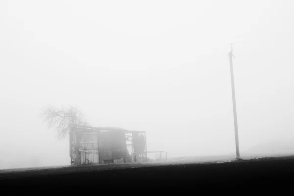 Granero y pilar en la niebla en la aldea — Foto de Stock