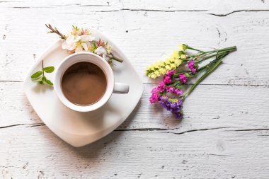 Gövde ile çiçekler üzerinde sıcak içecek fincan