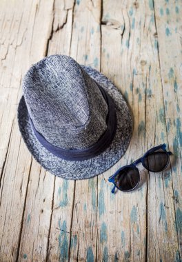Sunhat ve ahşap masa üzerinde güneş gözlüğü