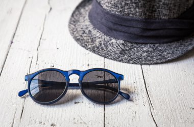 Sunhat ve ahşap masa üzerinde güneş gözlüğü
