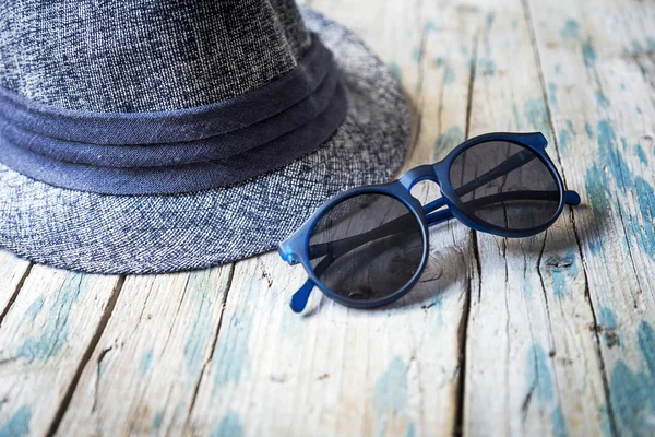 Chapeau et lunettes de soleil sur table en bois — Photo