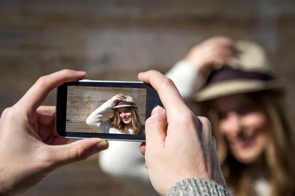 Mooie jonge vrouw die lacht op mobiele telefoon — Stockfoto