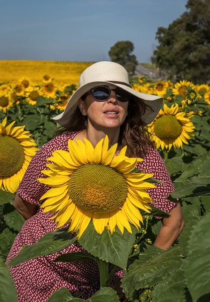 Rückansicht einer Frau mit Hut, die Sonnenblume betrachtet — Stockfoto