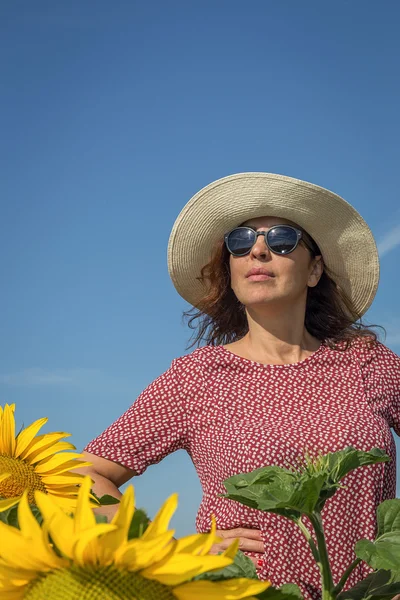Rückansicht einer Frau mit Hut, die Sonnenblume betrachtet — Stockfoto