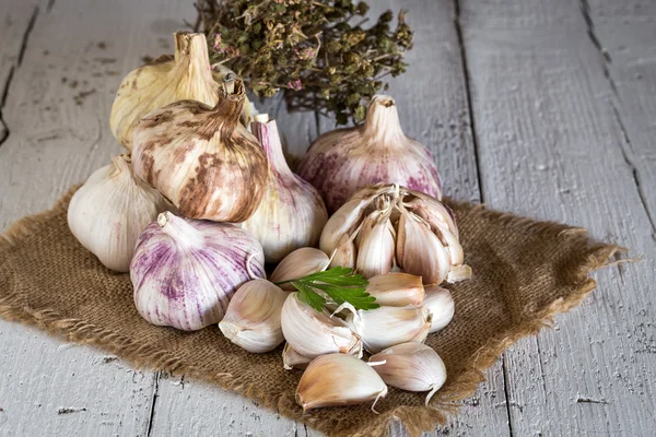 Purple garlics na ubrousek na stůl dřevěný rustikální — Stock fotografie