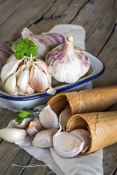 Lila garlics på en servett på ett rustikt träbord — Stockfoto