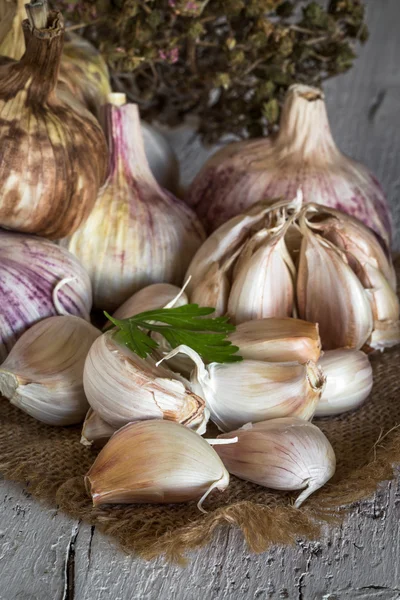 Lila garlics på en servett på ett rustikt träbord — Stockfoto