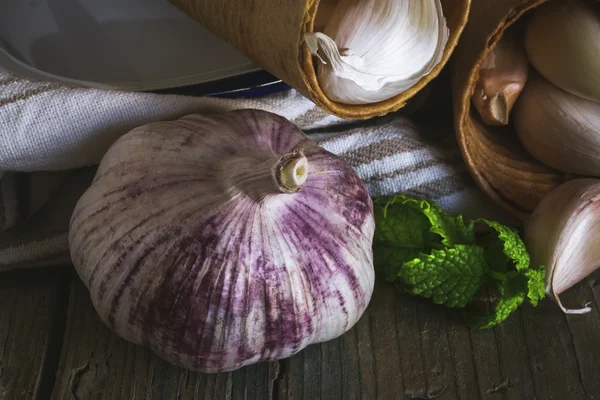 Purple garlics on a napkin on a wooden rustic table — Stock Photo, Image