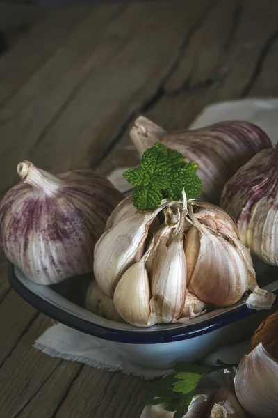 Lila garlics på en servett på ett rustikt träbord — Stockfoto