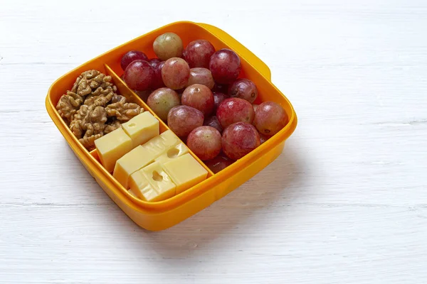 プラスチック容器の健康食品は 作業台の上にチーズ ブドウ クルミで食べる準備ができています Take Away Walnuts — ストック写真