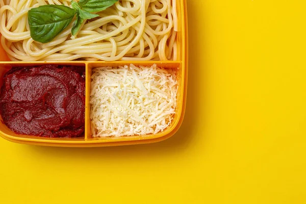 Healthy Food in Plastic containers ready to eat with homemade spaghetti with tomato, cheese and basil on the work table. Italian food. To take away.