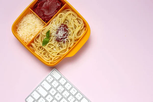 Healthy Food in Plastic containers ready to eat with homemade spaghetti with tomato, cheese and basil on the work table. Italian food. To take away.