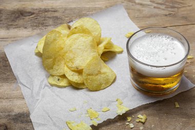 Evde patates cipsi, bira, kraker, yeşil ve siyah zeytinli çerezler var.