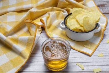 Evde patates cipsi, bira, kraker, yeşil ve siyah zeytinli çerezler var.