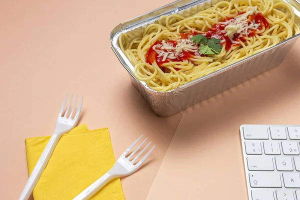 職場での昼食は自家製で健康的なスパゲティトマトとチーズをコンピュータキーボードで作業台で オフィスのコンセプトのためのホームフード 食べ物を奪う — ストック写真