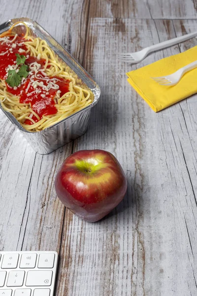 職場での昼食は自家製で健康的なスパゲティトマトとチーズをコンピュータキーボードで作業台で オフィスのコンセプトのためのホームフード 食べ物を奪う — ストック写真