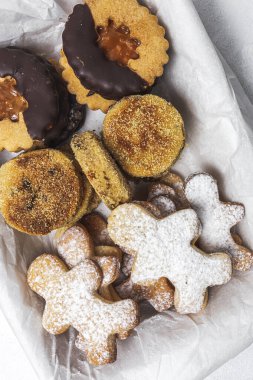 Beyaz arka planda ev yapımı zencefilli ekmek, tarçınlı ve çikolatalı kurabiyeler. Düz yatıyordu