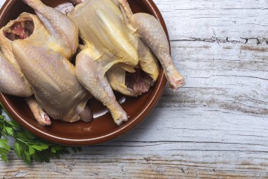 Pişirmeye hazır çiğ sebzeli koka tavukları. Havuç, pırasa; tatlı patates; yukarıdan maydanoz. Düz yatıyordu