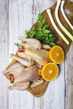 Pişirmeye hazır çiğ sebzeli koka tavukları. Havuç, pırasa; tatlı patates; yukarıdan maydanoz. Düz yatıyordu