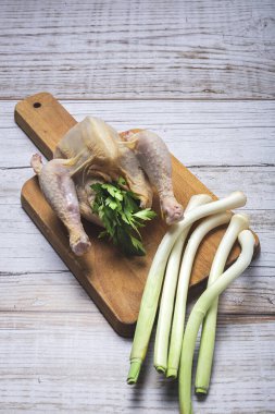 Pişirmeye hazır çiğ sebzeli koka tavukları. Havuç, pırasa; tatlı patates; yukarıdan maydanoz. Düz yatıyordu