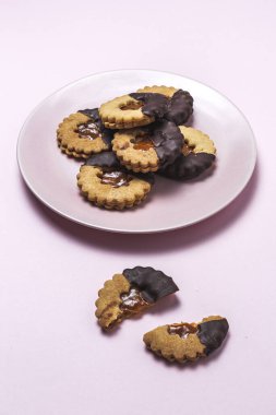 Ev yapımı zencefilli ekmek, tarçın ve pembe arka planda çikolatalı kurabiyeler. Düz yatıyordu