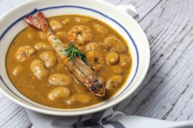 Geleneksel ev yapımı karidesli beyaz fasulye güveci. Tipik İspanyol yemekleri. ahşap arkaplanda