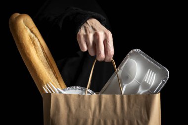 Koyu bir geçmişi olan, yemek poşetleri götüren tanınmamış bir kadın. Yemek yemek için hazır. Kargo