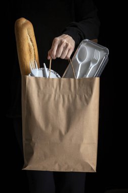 Koyu bir geçmişi olan, yemek poşetleri götüren tanınmamış bir kadın. Yemek yemek için hazır. Kargo