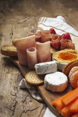 Sağlıklı Brunch masası jambon, çilek, kivi; ekmek; kurabiye; peynir, havuç, mandalina, humus; teslimat konsepti