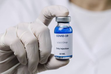 COVID-19 aşısı araştırmacıların elinde tanınmayan kadın doktor Coronavirus aşısı için şırınga ve şişe tutuyor. Corona virüsü tedavisi kavramı