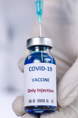 COVID-19 aşısı araştırmacıların elinde tanınmayan kadın doktor Coronavirus aşısı için şırınga ve şişe tutuyor. Corona virüsü tedavisi kavramı