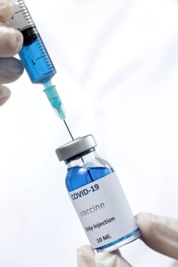 COVID-19 aşısı araştırmacıların elinde tanınmayan kadın doktor Coronavirus aşısı için şırınga ve şişe tutuyor. Corona virüsü tedavisi kavramı