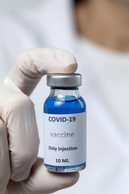 COVID-19 aşısı araştırmacıların elinde tanınmayan kadın doktor Coronavirus aşısı için şırınga ve şişe tutuyor. Corona virüsü tedavisi kavramı