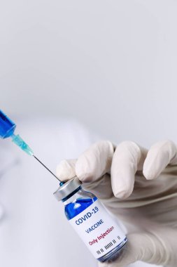 COVID-19 aşısı araştırmacıların elinde tanınmayan kadın doktor Coronavirus aşısı için şırınga ve şişe tutuyor. Corona virüsü tedavisi kavramı