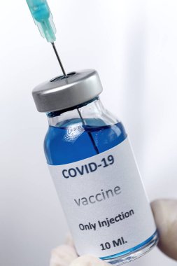 COVID-19 aşısı araştırmacıların elinde tanınmayan kadın doktor Coronavirus aşısı için şırınga ve şişe tutuyor. Corona virüsü tedavisi kavramı