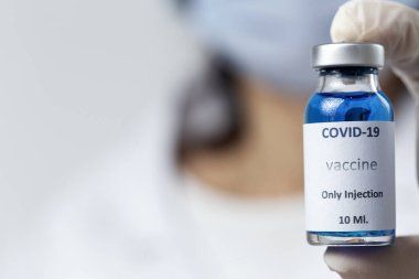 COVID-19 aşısı araştırmacıların elinde tanınmayan kadın doktor Coronavirus aşısı için şırınga ve şişe tutuyor. Corona virüsü tedavisi kavramı